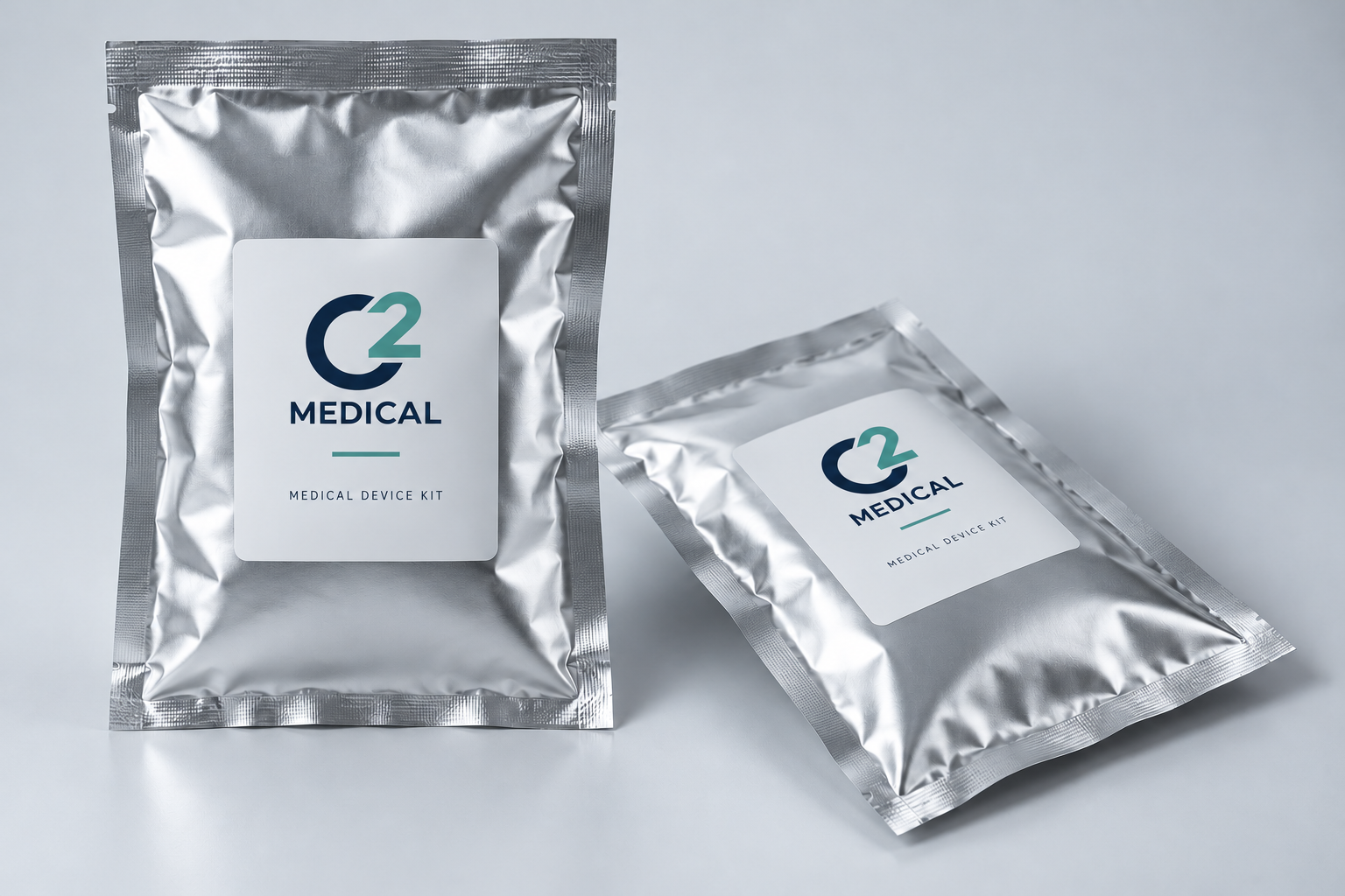 Illustrative C² Medical packaging concept showing two silver foil kit pouches with white and navy labels